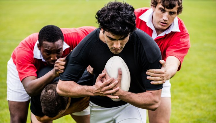 Rugby players tackling during game