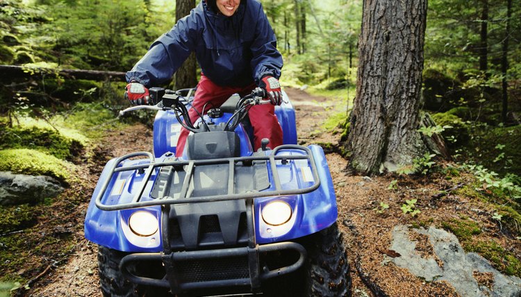 Woman driving ATV through forest