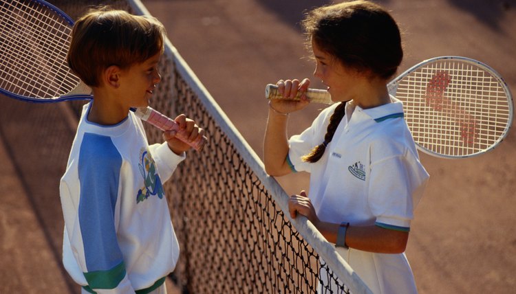 Children (6-9) face to face on tennis court
