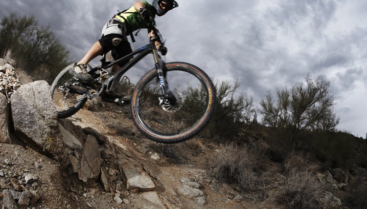 Man mountain biking down steep rocky path, low angle view