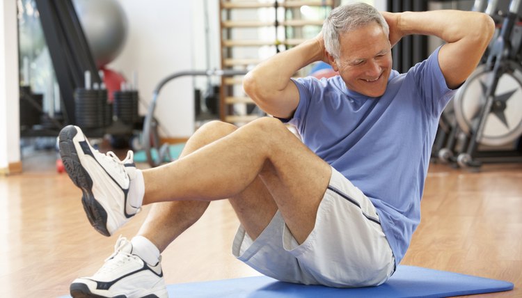 Senior Man Doing Sit Ups In Gym