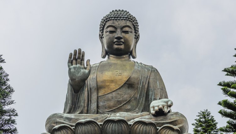 A large Buddha statue sitting on a pedestal in Hong Kong.