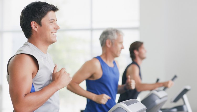 Men running on treadmills in gymnasium