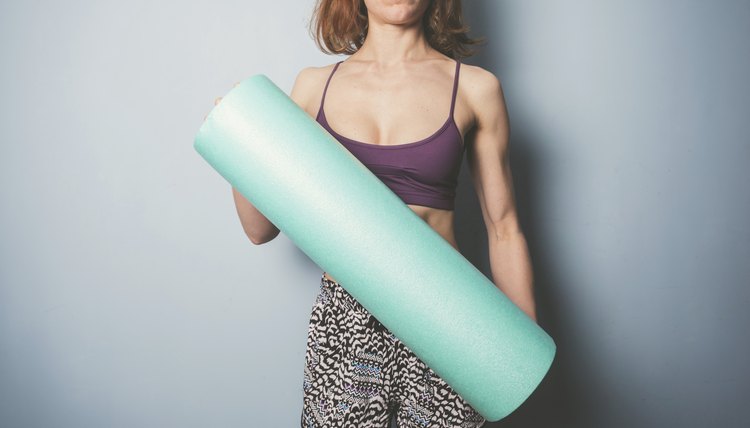 Athletic young woman with foam roller
