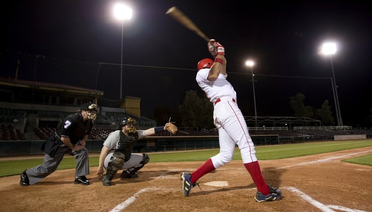 USA, California, San Bernardino, baseball players with batter swinging