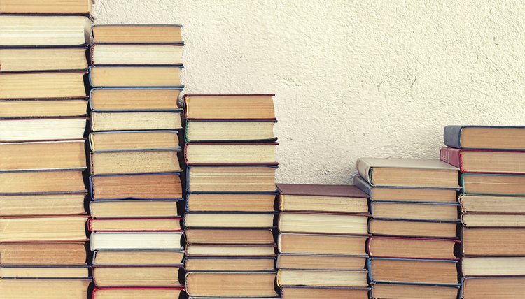 Piles of books leaning against a wall.