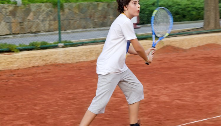 The boy is playing tennis