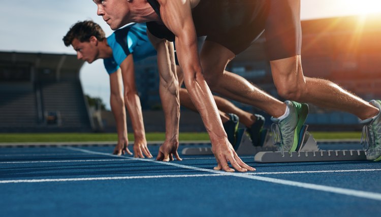 Fit athlete running race in athletics racetrack