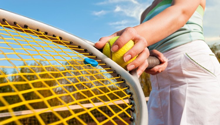 Dynamic tennis concept with female player holding ball and racke