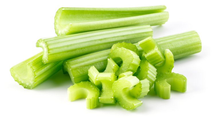 Green fresh celery sticks and pieces isolated on white