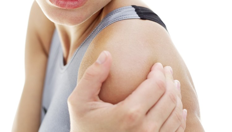 young woman holding her shoulder in pain