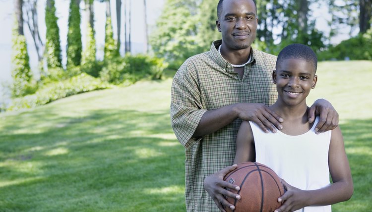 Father and his son smiling holding a basketball