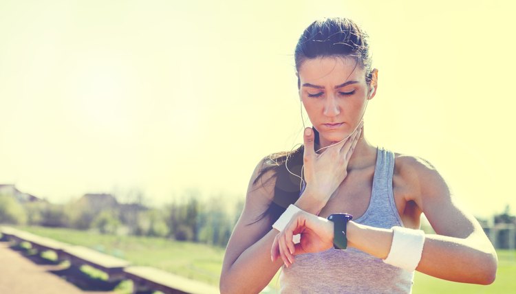 Young woman measuring heart rate after running