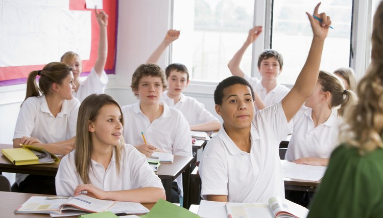 Students raising hands in classroom