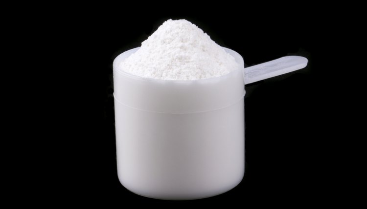 Scoop of whey protein isolated on black