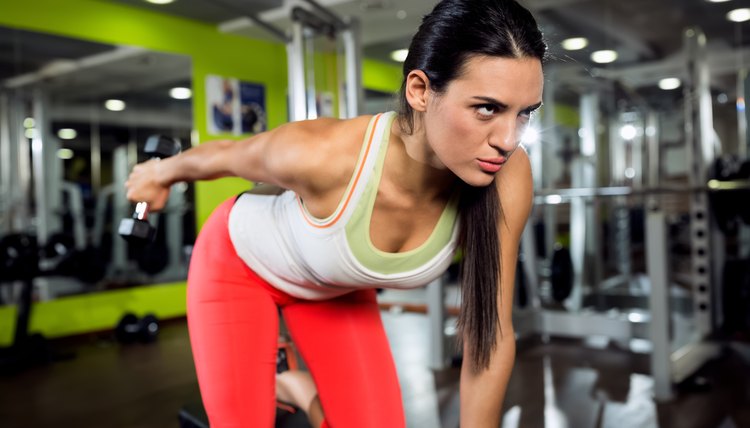 Strong fitness angry girl doing training with weight