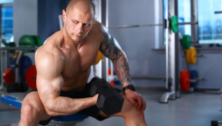 Young handsome man sits after workout in the gym