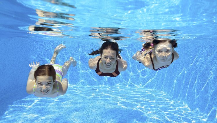 Happy family swim underwater in pool