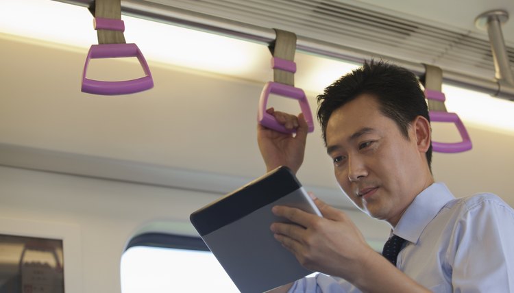 Business man looking at a computer table on the train.