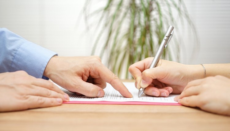 man is pointing place where she should sign the agreement