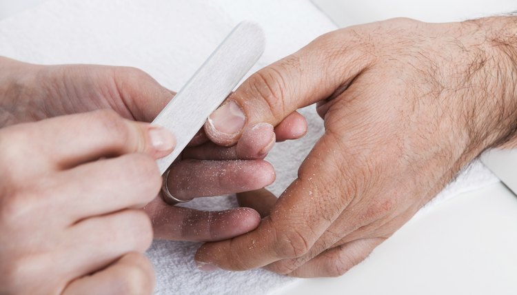 Man's hands getting a manicure.