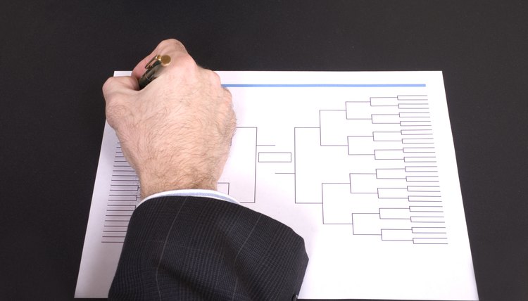 March Madness Businessman Hand Filling In Bracket From Above