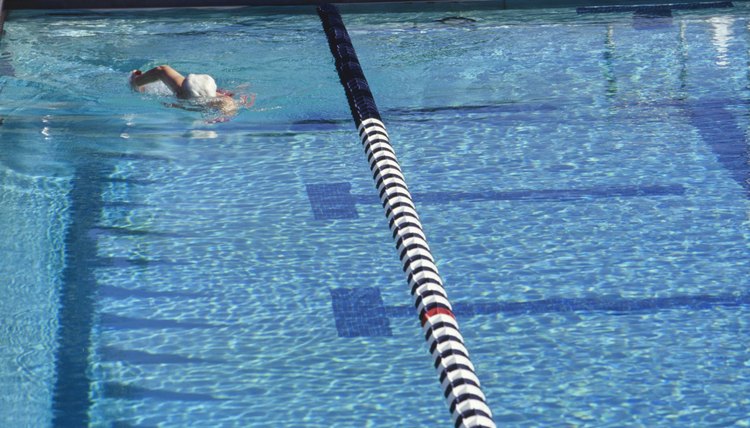 Senior woman swimming in outdoor pool, elevated view