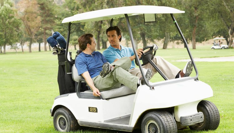 Two men riding in golf cart