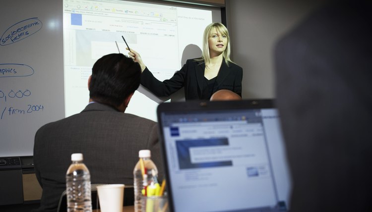 Businesswoman presenting by projection screen, low angle view