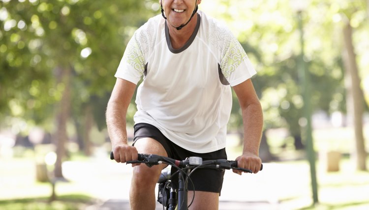 Mature Man Cycling Through Park