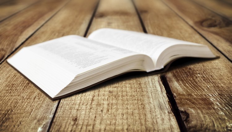 Open bible on wood table.