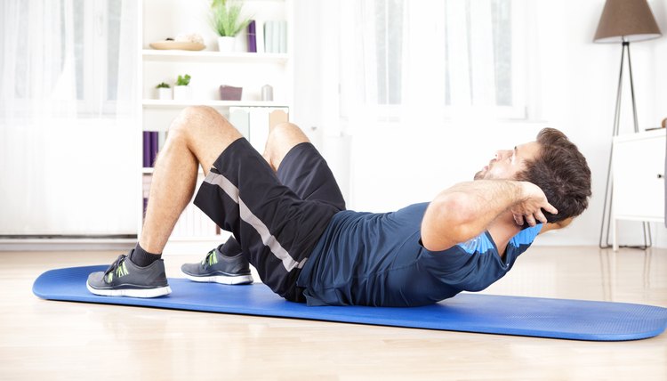 Athletic Young Man Doing Indoor sit Ups Exercise for Abdomen on Top of a Mat at Home.