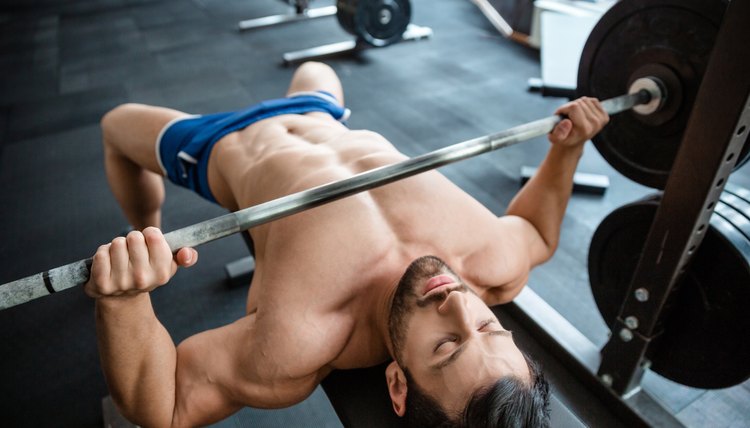 Muscular man doing bench press