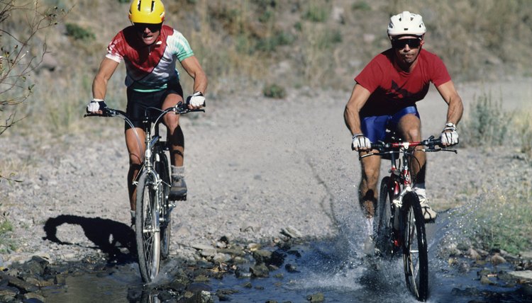 Two mountain bikers riding through water, Sun Valley, Idaho, USA
