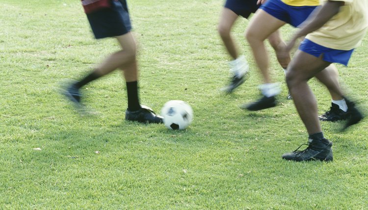 People playing football outdoors,low section