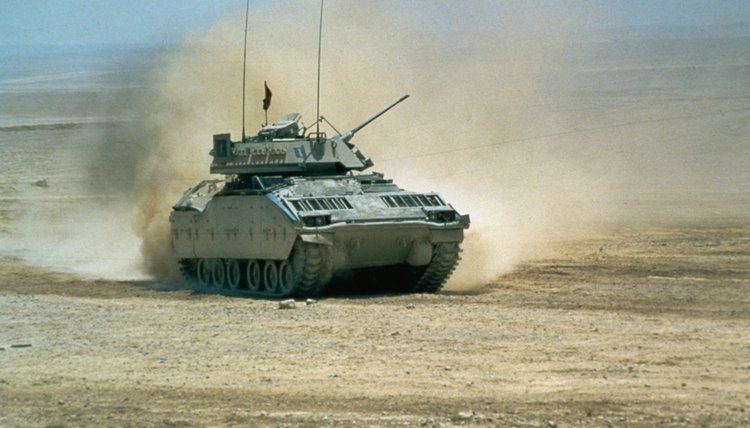 Military tank going through desert