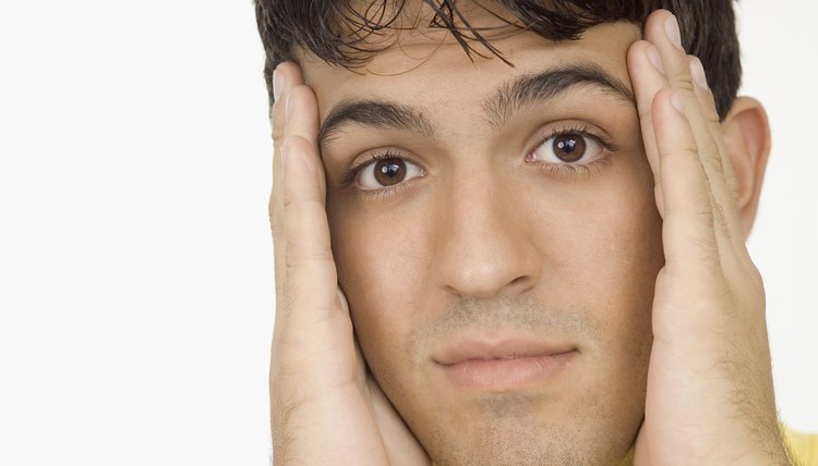 Young man holding his head, close-up