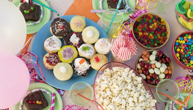 Party table with cupcakes, popcorn, and candies