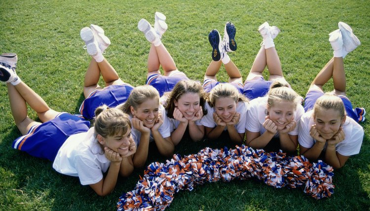 High angle view of cheerleaders (16-17) lying on lawn