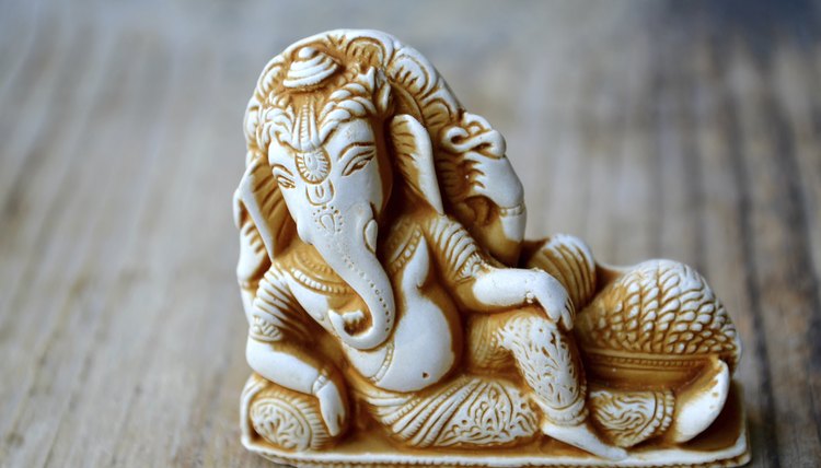 A statue of the Hindu idol, Ganesh, on a wooden table.