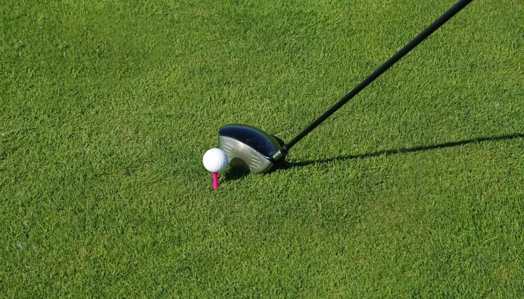 Golf club and ball in grass