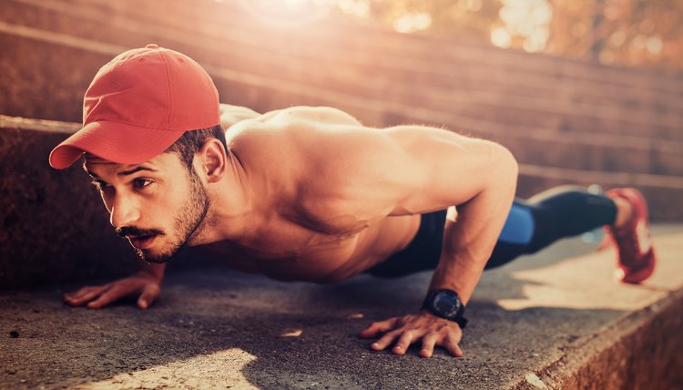 Portrait of a fitness man doing push ups outdoors.