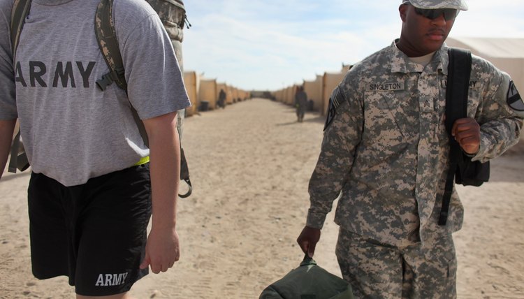 Army sergeant carry gear to staging area