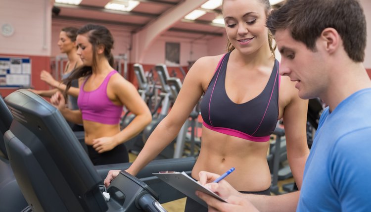 Trainer helping a woman in a gym