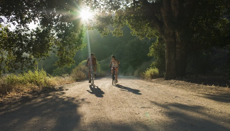 young couple biking down dirt road