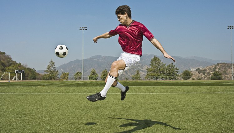 Jumping soccer player kicking ball