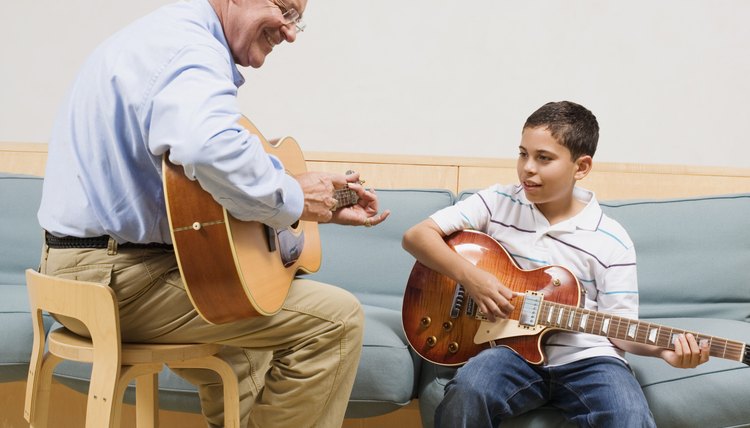 Teacher and student playing guitars