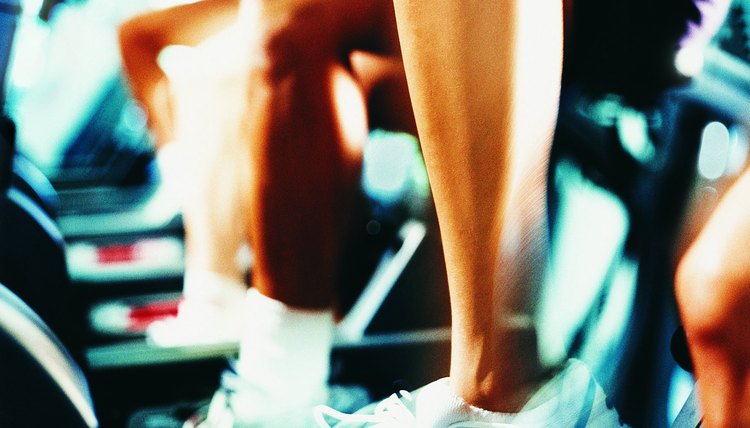 Legs and feet of women riding stationary bicycles