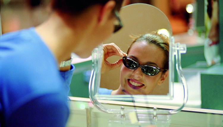 Woman trying on a pair of sunglasses.