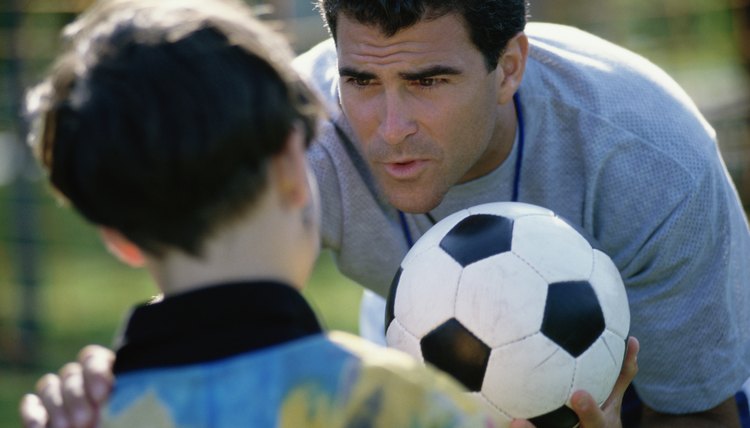 Soccer coach standing with his hand on a boy's shoulder